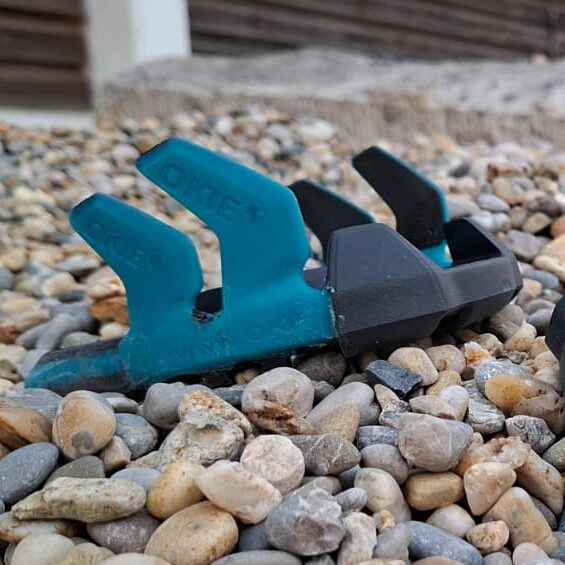 Okie Klebebeschlag mit blauen Klebelaschen. Hufschutz auf Kies